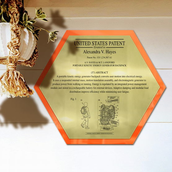 Honeycomb Patent Plaque With Orange Acrylic Board And Gold Plate Printed With Sample Details Mounted Onto Wall Near Plant