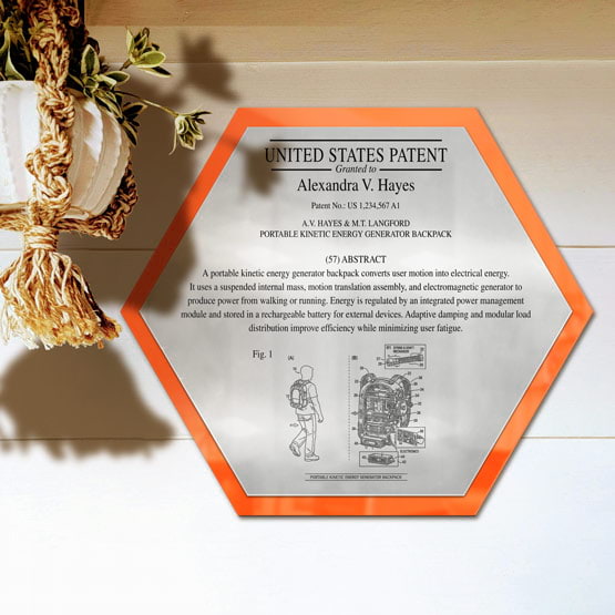 Honeycomb Patent Plaque With Orange Acrylic Board And Silver Plate Printed With Sample Details Mounted Onto Wall Near Plant