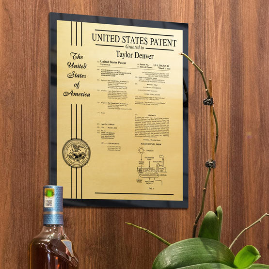 Custom Printed Acrylic Patent Plaque With Gold Metal On Beige Wall.