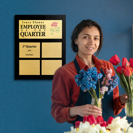 Woman Arranging Flowers In Front Of Custom Employee Of The Quarter Plaque For Ivory Flower. 