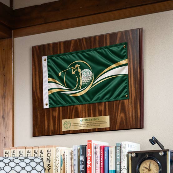 Walnut Plaque With Green Golf Themed Flag And Gold Plate Printed With Golf Award Message Mounted On Wall Above Bookshelf