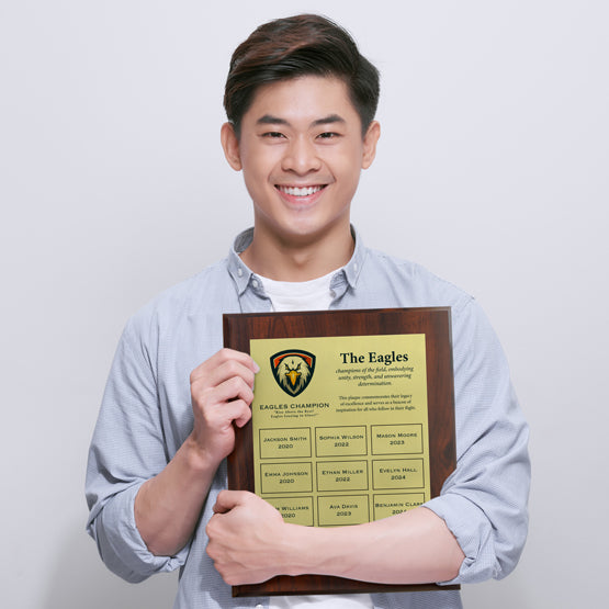Young Man Holding Economy Same Day Perpetual Plaque Award For Champions With Gold Aluminum Plates And Wood Board 