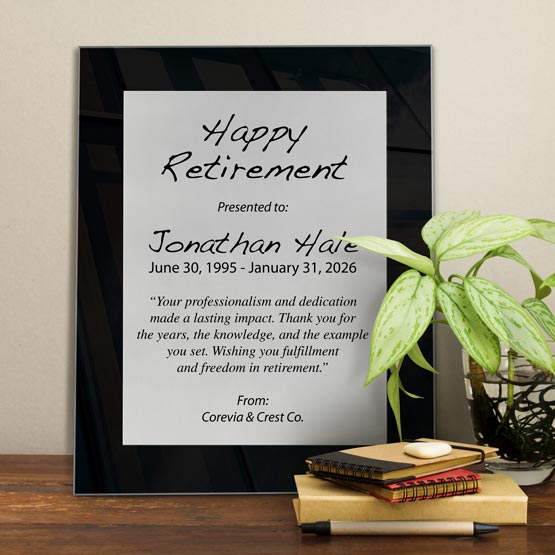 Silver Aluminum Plaque With Black Acrylic Board And Printed With Happy Retirement Message On Shelf With Plant And Notebooks