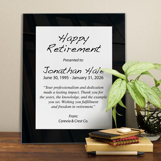 White Aluminum Plaque With Black Acrylic Board And Printed With Happy Retirement Message On Shelf With Plant And Notebooks