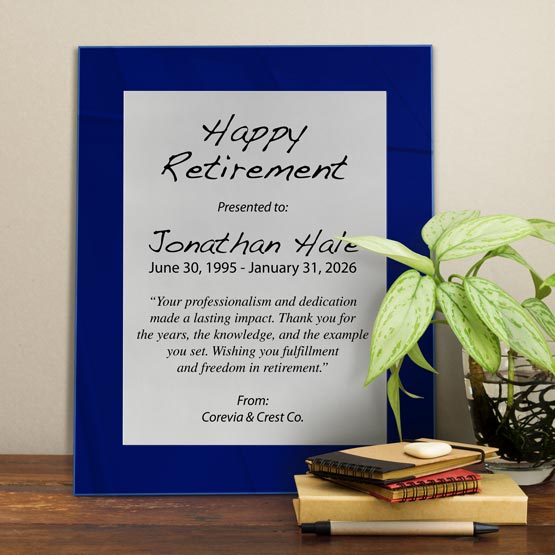 Silver Aluminum Plaque With Blue Acrylic Board And Printed With Happy Retirement Message On Shelf With Plant And Notebooks