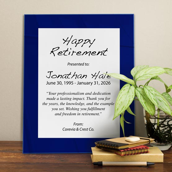 White Aluminum Plaque With Blue Acrylic Board And Printed With Happy Retirement Message On Shelf With Plant And Notebooks