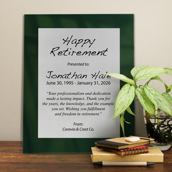 Silver Aluminum Plaque With Green Acrylic Board And Printed With Happy Retirement Message On Shelf With Plant And Notebooks