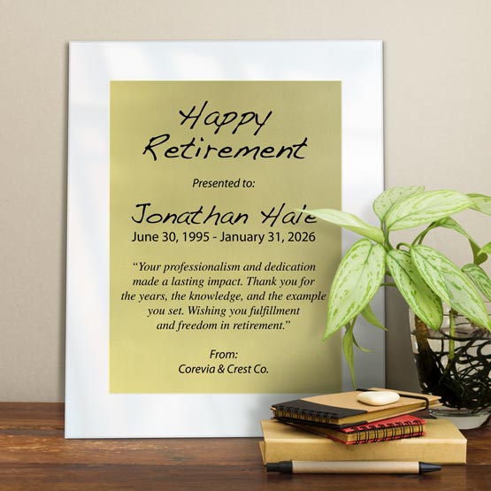 Gold Aluminum Plaque With White Acrylic Board And Printed With Happy Retirement Message On Shelf With Plant And Notebooks