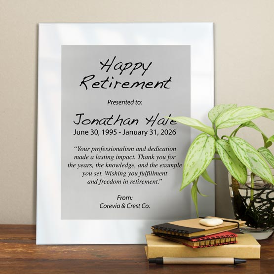 Silver Aluminum Plaque With White Acrylic Board And Printed With Happy Retirement Message On Shelf With Plant And Notebooks