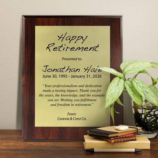 Gold Aluminum Plaque With Cherry Board And Printed With Happy Retirement Message On Shelf With Plant And Notebooks