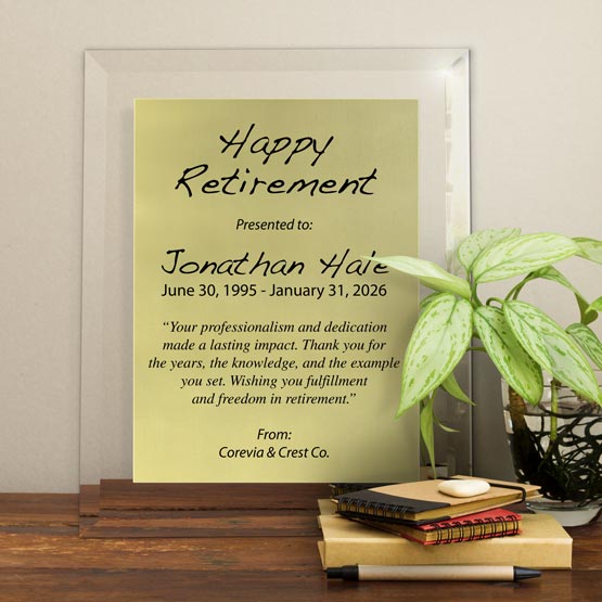 Gold Aluminum Plaque With Glass Board And Printed With Happy Retirement Message On Shelf With Plant And Notebooks