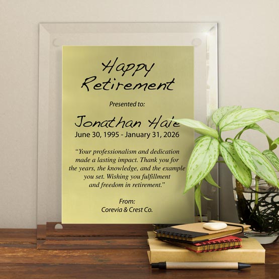 Gold Aluminum Plaque With Glass Board With Holes And Printed With Happy Retirement Message On Shelf With Plant And Notebooks