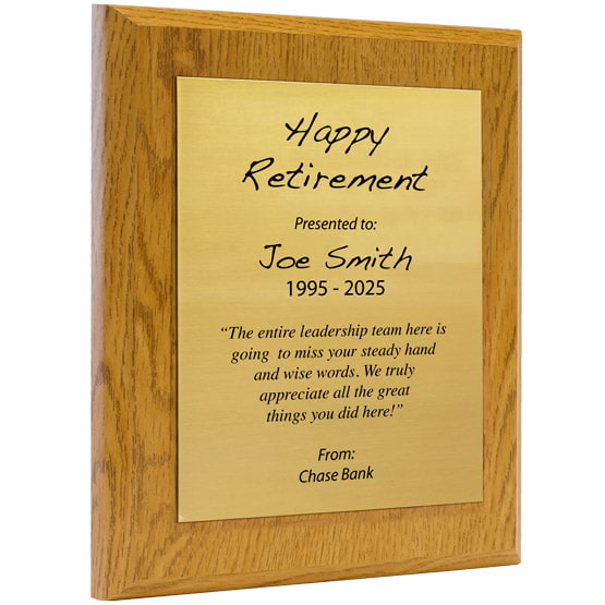 Custom Gold Aluminum Plaque With Oak Board And Printed With Happy Retirement Message Against A White Background