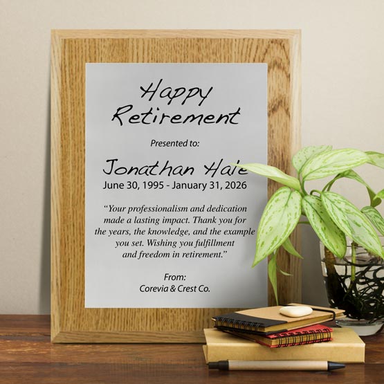 Silver Aluminum Plaque With Oak Board And Printed With Happy Retirement Message On Shelf With Plant And Notebooks