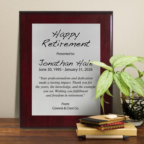 Silver Aluminum Plaque With Rosewood Board And Printed With Happy Retirement Message On Shelf With Plant And Notebooks