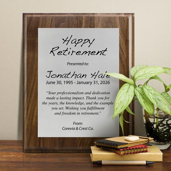 Silver Aluminum Plaque With Solid Walnut Board And Printed With Happy Retirement Message On Shelf With Plant And Notebooks