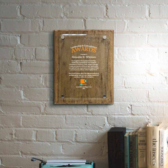 Barnwood Floating Glass Plaque Printed With Leadership Award Message And Logo Mounted On Brick Office Wall Above Books