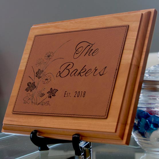 Plaque With Wood Board And Rawhide Faux Leather Plate With Family Name And Date And Flower Art Standing Via Easel On Table