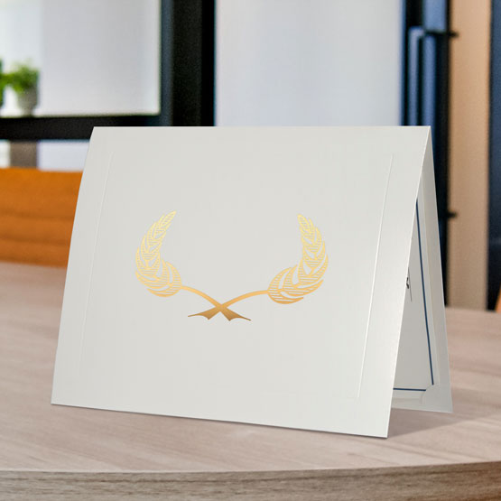 White Chipboard Presentation Folder With Gold Wheat Art And Slightly Opened To Show Certificate Inside On A Wood Table