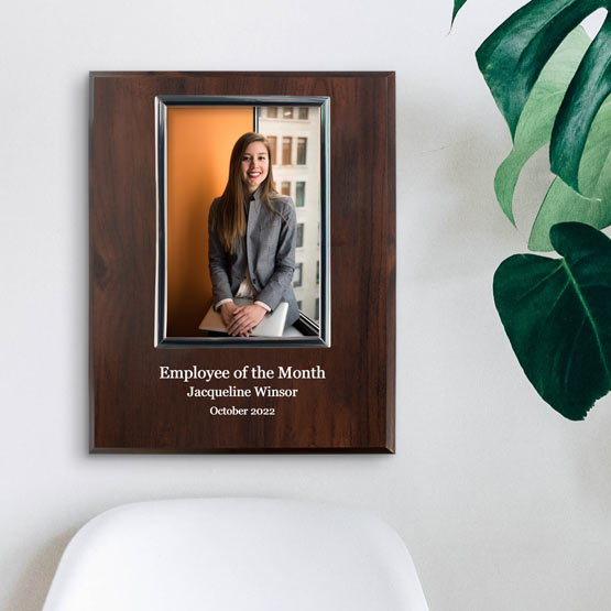 Photo Plaque Award For Employee Of The Month With Wood Board And Employee Photo And Details On Office Wall By Chair And Plant