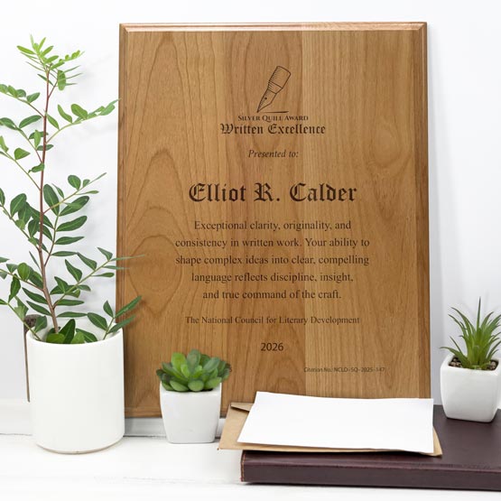 Solid Red Alder Wood Plaque Engraved With Award Message And Logo On A White Office Desk With Potted Plants And Notebook