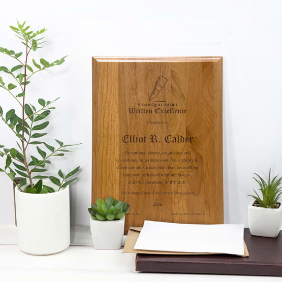 Solid Red Alder Wood Plaque Engraved With Award Message And Logo On A White Office Desk With Potted Plants And Notebook