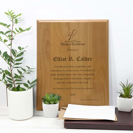 Solid Red Alder Wood Plaque Engraved With Award Message And Logo On A White Office Desk With Potted Plants And Notebook