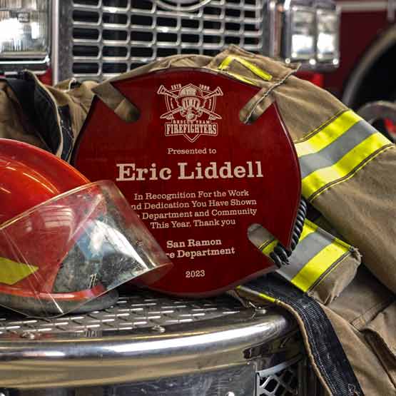 Maltese Cross Rosewood Plaque Award For Years Of Firefighter Service Displayed On Fire Truck Grill With Jacket And Helmet
