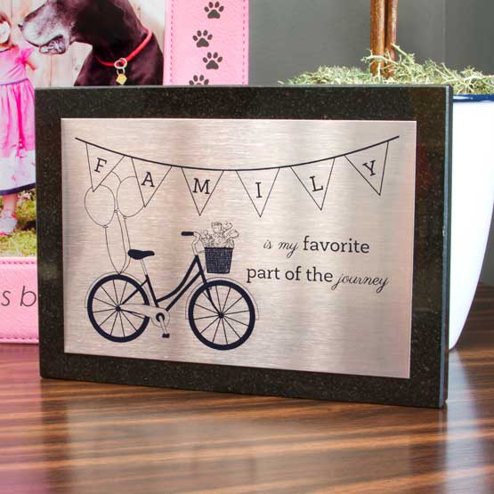Stainless Steel Plaque With Bike Art And Family Journey Message On Granite Board And Standing On Table With Potted Plant