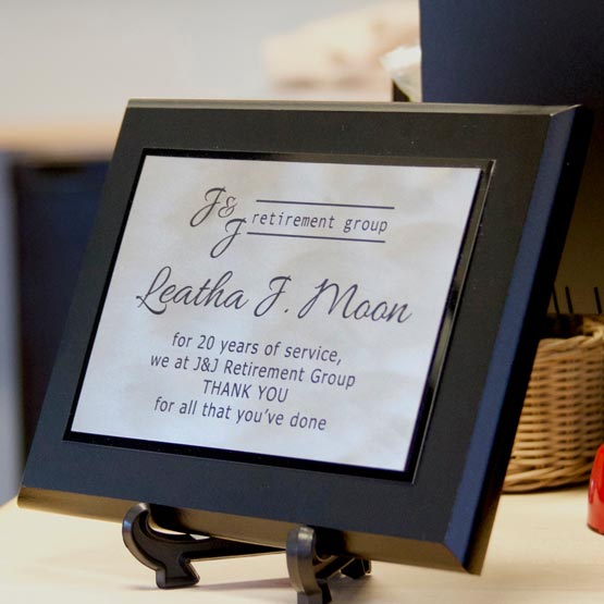 Custom Titanium Plaque Award For Years Of Service With Black Board And Easel On Office Desk With Computer Monitor