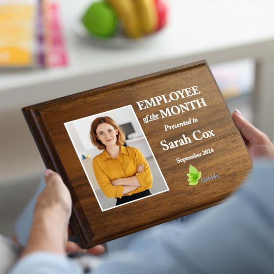 Woman Hands In Living Room Holding Solid Walnut Plaque Award For Employee Of The Month With Photo And Message And Logo
