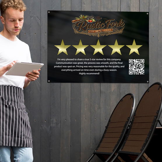 Five Star Review Black Acrylic Sign Printed With Logo And Review Text And QR Code On Restaurant Wall Near Chairs And Waiter