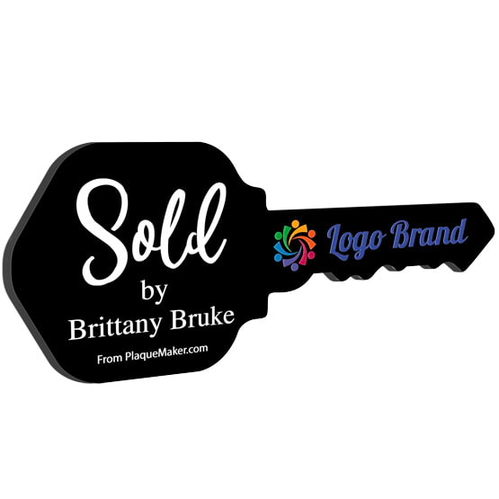 House Key Shaped Black Acrylic Sign Color Printed With Sold By Message And Sample Logo And Name Against White Background