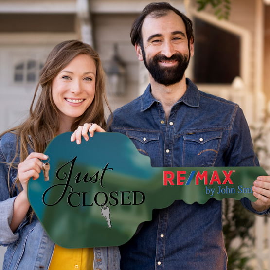 Happy Couple Outside Home Holding A House Key Shaped Green Acrylic Sign Printed With Just Closed Message And Logo And Name