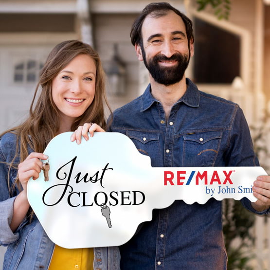 Happy Couple Outside Home Holding A House Key Shaped White Acrylic Sign Printed With Just Closed Message And Logo And Name