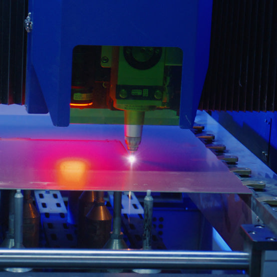 Laser cutting machine in operation cutting clear acrylic in dark room