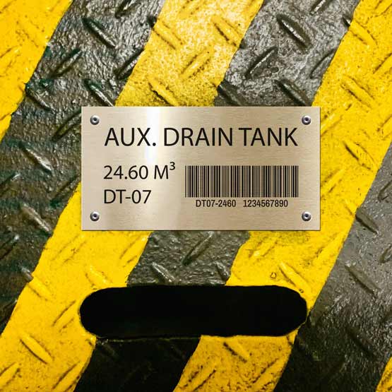 Silver Aluminum Bar Code Tag Printed With Drain Tank Details And Barcode Mounted Onto Yellow And Black Grate