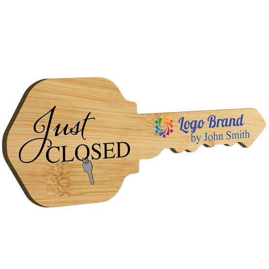 House Key Shaped Bamboo Sign Color Printed With Just Closed Message And Sample Name And Logo Against White Background