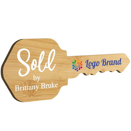 House Key Shaped Bamboo Sign Color Printed With Sold By Message And Sample Name And Logo Against White Background