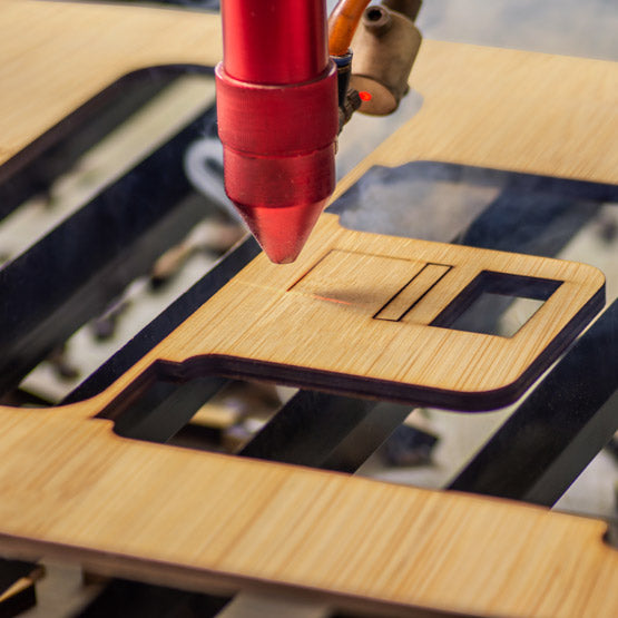 Laser engraving machine in action on a wooden surface