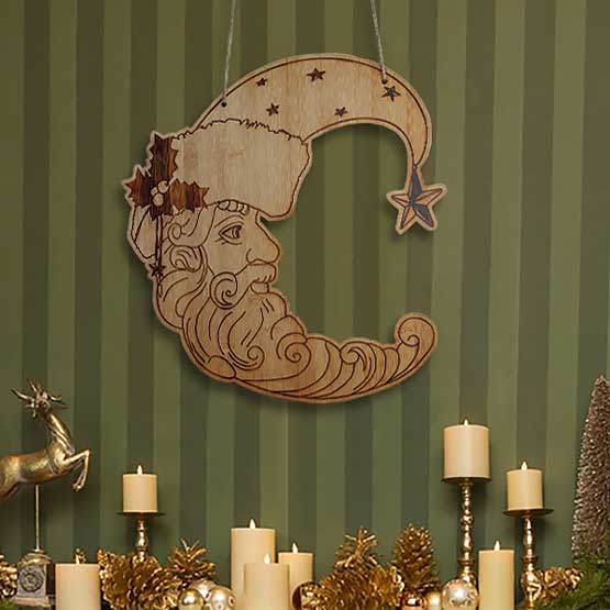 Crescent Bamboo Sign Engraved With Detailed Santa Claus Art Hanging Via Twine On Wall Above Festive Shelf With Candles