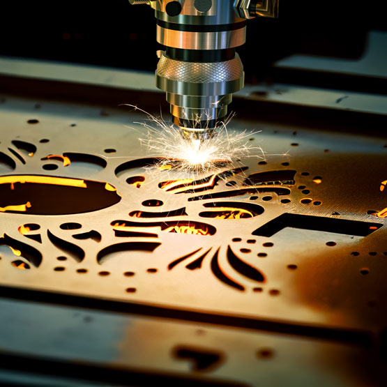 An industrial laser machine cuts intricate designs into solid brass metal.