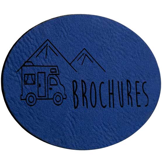 Oval Blue And Black Faux Leather Label Engraved With Truck And Mountains Art And Brochures Text Against White Background