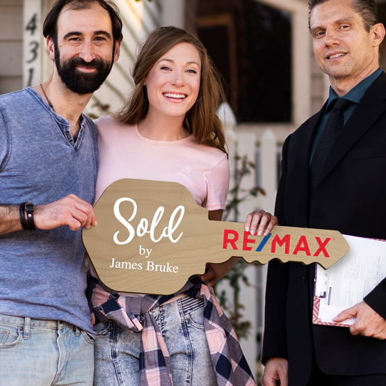 Realtor Posing Outdoors With Happy Couple Holding House Key Shaped Red Alder Wood Sign Printed With Sold By Message And Logo