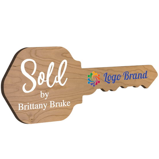 House Key Shaped Cherry Wood Sign Color Printed With Sold By Message And Sample Name And Logo Against White Background