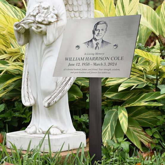 Stainless Steel Sign Laser Fused With Memorial Details And Picture Displayed Outdoors Near Statue Via Sign Stand