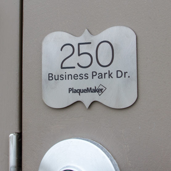Small Titanium Address Sign Laser Fused With PlaqueMaker Logo And Address Mounted On Gray Door Above Silver Handle