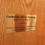 Order 605739 Review Image. Brass sign attached to a door that reads Coshocton Driver Training.