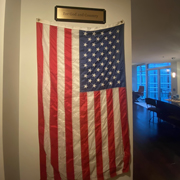Order 808567 Review Image. Bronze Sign with Black Acrylic backing, mounted to a wall above an American Flag.