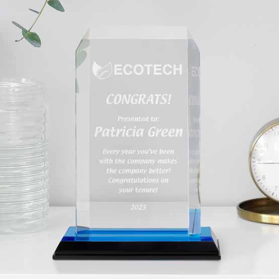 Blue Acrylic award with clipped corners sitting on desk, completely customizable with laser-engraving or UV color printing.